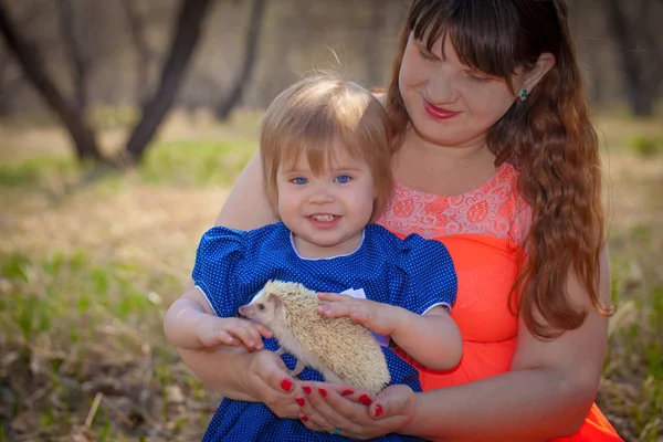 Familienkonzept. Mutter und Tochter spielen mit einem Igel. — Stockfoto