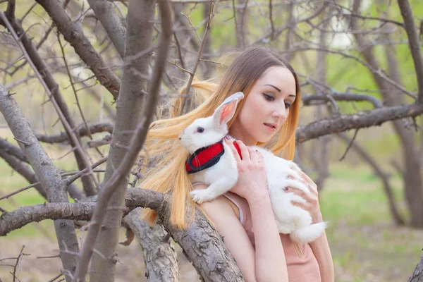 Het meisje met het witte konijn. Mooie vrouw die een haas vasthoudt. — Stockfoto