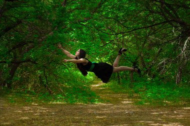 Uyku kavramı. Siyah elbiseli bir kız ormanda uçuyor..