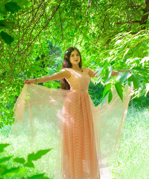 Красива дівчина в персиковій сукні в повному зростанні. Модель позування в довгій сукні . — стокове фото