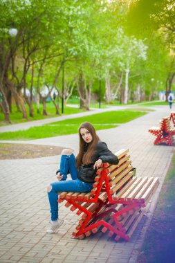 Güzel kız poz veriyor. Bir kadın yıldız şeklinde bir bankta oturur. A