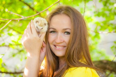 Mutluluk kavramı. Güzel kız bir kirpiye sarılıyor..