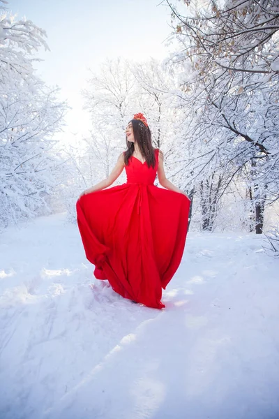 Βασίλισσα σε ένα κόκκινο στέμμα ανάμεσα στο χειμερινό δάσος. Υπέροχο κορίτσι σε ένα... — Φωτογραφία Αρχείου