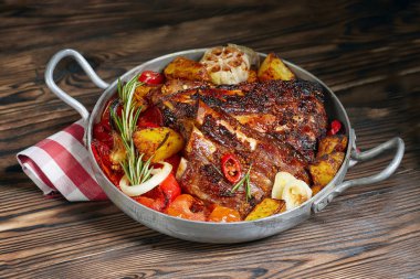 Biberiye, rustik patates, soğan, bir tavada kızarmış kaburga sosu. Koyu arka plan.