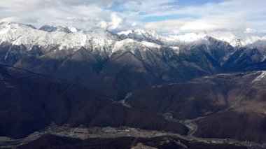 Dağlar karlı zirveleri ve gökyüzü bulutlu