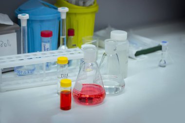 Laboratuvar tabloda reaktifler renkli şişeler içinde yanıyor