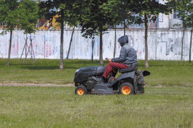 Bir adam bir traktör çim biçme makinesi üzerinde çim mows