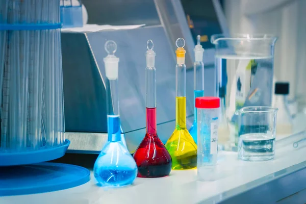 Laboratuvar tabloda reaktifler renkli şişeler içinde yanıyor