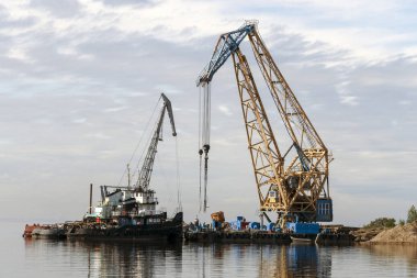 Ürünler su üzerinde yüzen vinçler yüklü