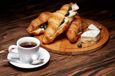 Ay çöreği, Camembert peyniri, ahşap arka plan üzerinde yaban mersini ile kahve.