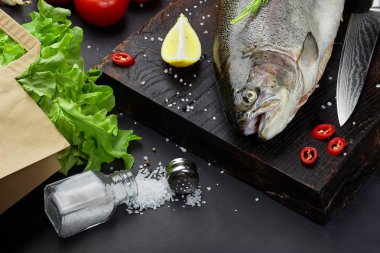 Malzemeler - sağlıklı gıda, diyet veya pişirme kavramı ile balık. Tüm çiğ balık karanlık vintage doku. Gıda arka plan, üstten görünüm, düz yatıyordu tarzı.