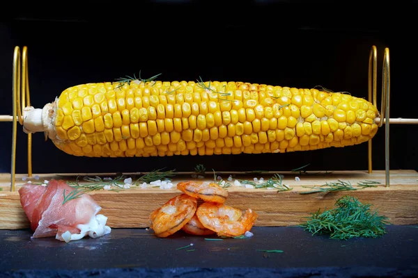 Grilled corn cob with bacon, salt and herbs. Grilled corn cob with bacon, salt and herbs.  Concept of feed corn in the restaurant