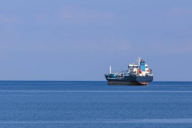 deniz ufkunun bir arka plan karşı denizde deniz kargo gemisi ve bulutsuz bir gökyüzü