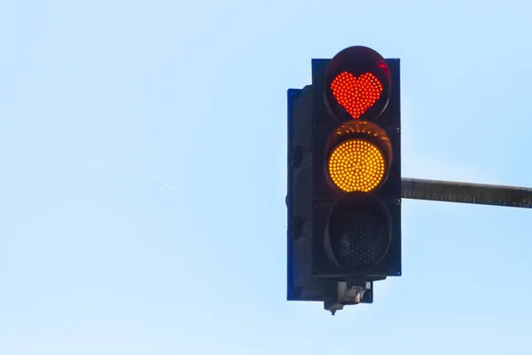 Trafik ışığı kırmızı kalp şeklinde sinyal mavi gökyüzü karşı