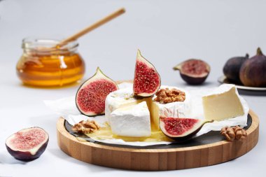 Camembert peyniri ambalaj kağıdı ile incir, fındık ve bal