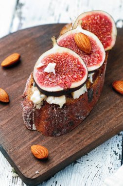 İncir, peynir ve bir fincan kahve ahşap zemin ile sandviç.