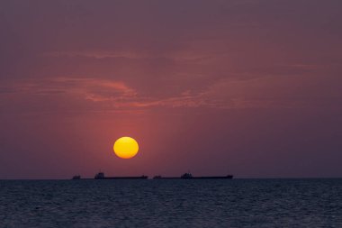 Gün batımında gemiler ufukta yüzer