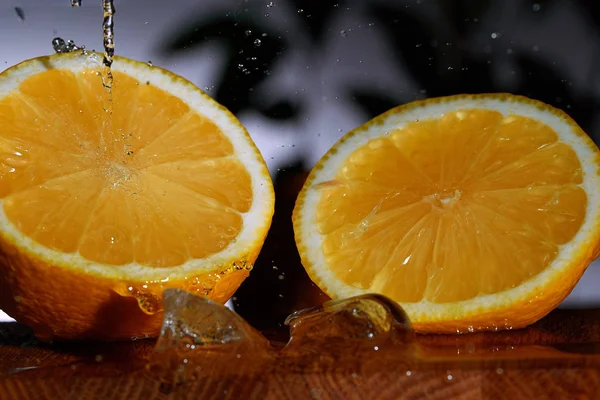 The orange cut in half on a wooden table.