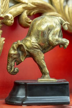 bronze statuette of an elephant in a interior red background clipart