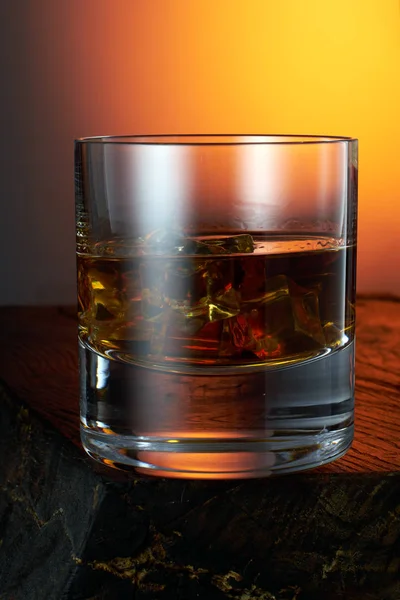 Pohár whisky jéggel egy fából készült asztal. közelíti — Stock Fotó