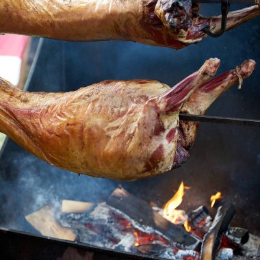İki koyun leşi dışarıdaki bir tükürükte kavrulur. yakın çekim