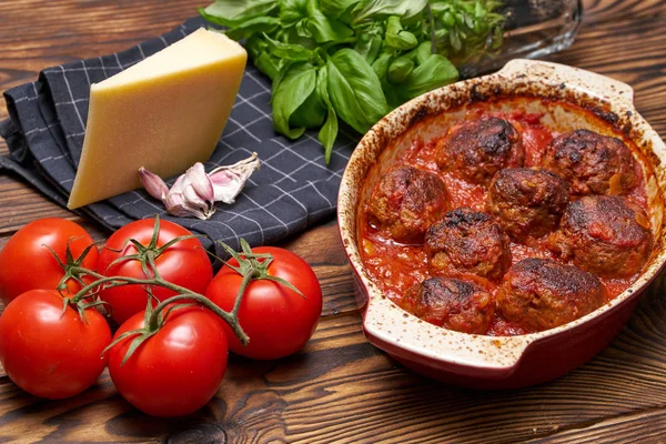 Domates soslu köfte. Köy masası. Seramik kasesi. Beyaz kafesli siyah peçete. Sert peynir, taze bazel, sarımsak.