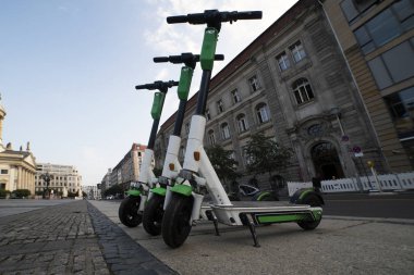 Berlin'de elektrikli scooter kiralama. Elektrikli scooter güneşli bir yaz gününde sokakta üst üste durmak. kaldırımda park elektrikli scooter