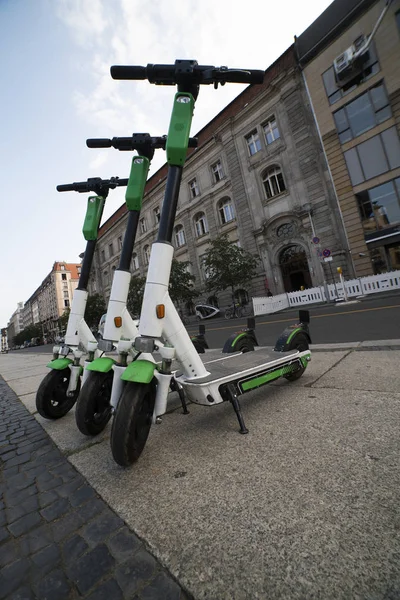 electric scooter rental in Berlin. Electric scooters stand in a row on the street on a sunny summer day. electric scooters parked on the sidewalk