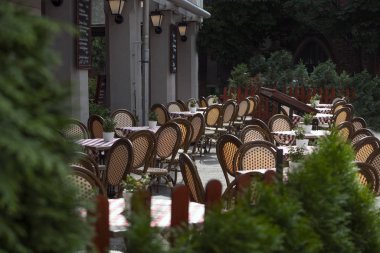 Kırmızı sandalyeli, kırmızı beyaz kareli masa örtüsü olan bir yazlık kafe. Güneşli bir günde, yaz terasında bedava masalar. İtalyan tarzı açık havada bir kafe.