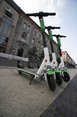 Üç elektrikli scooter caddeye park edilmiş. Kiralık e-scooter. Alternatif ulaşım Ekolojik taşıma. alt görünüm