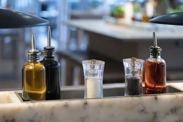 Conjunto de condimentos: aceite de oliva, vinagre, sal, pimienta en la mesa en el restaurante. condimento sobre la mesa. de cerca . Fotos de stock libres de derechos