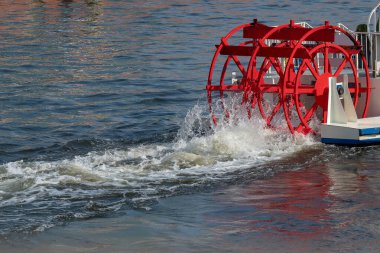 Suyu döndüren bir teknede kırmızı kürek çarkı