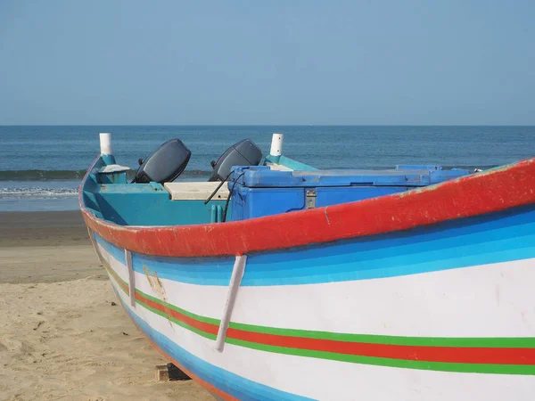 Un bateau de pêche se tient sur la plage pendant la journée . — Photo