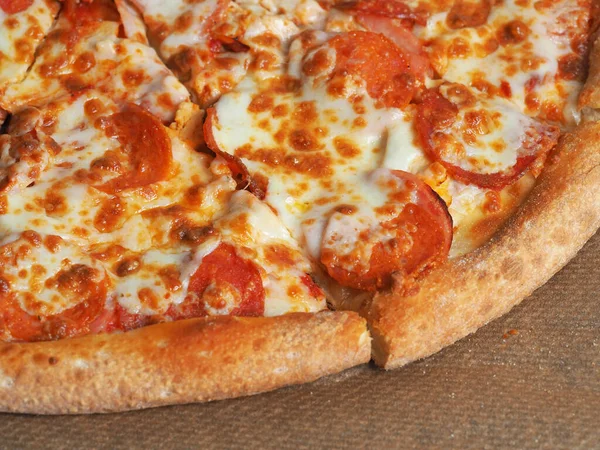 Vista superior de perto da pizza com presunto, Perroni e queijo. Prato italiano delicioso em casa — Fotografia de Stock