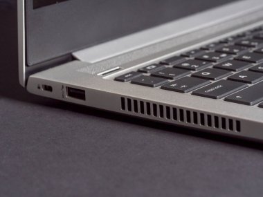 Gri arka planda alüminyumdan yapılmış açık dizüstü bilgisayarın bir parçası. Yan görünüm, boşluk kopyala.