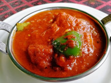 Kakai 'deki tavuk Tikka Masala, beyaz bir tabakta, yakın plan. Lezzetli Hint tavuğu.