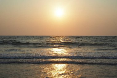 Yazın deniz ve plajın arka planında güzel bir günbatımı. Tatil ve tatil kavramı