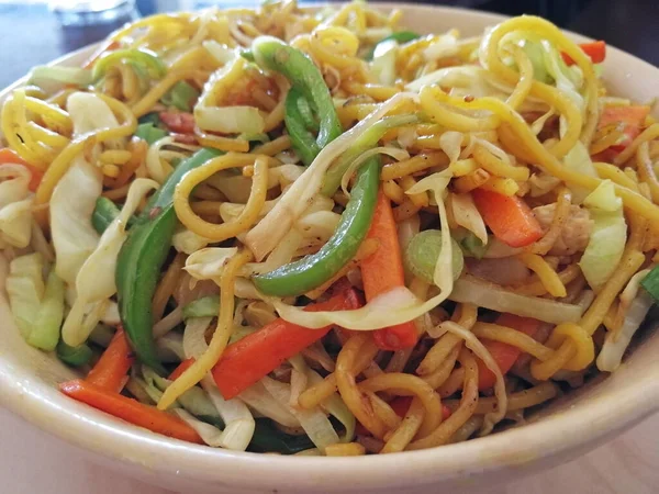 Bir kafede yakın mesafeden servis edilen sebzeli erişte kasesi. Asya mutfağından lezzetli yemekler.