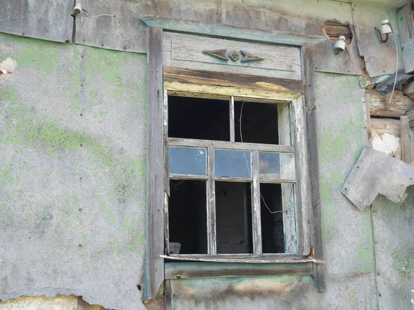 an old broken window of a house in the village with broken glass. Abandoned house. Countryside. sunny day