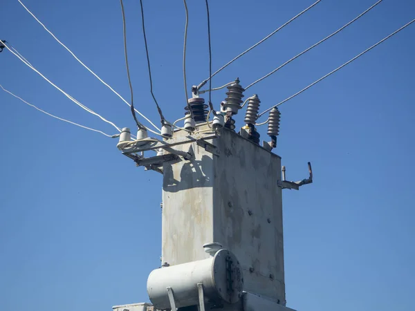 Old and rusty transformer station in summer on a clear day against the blue sky close up