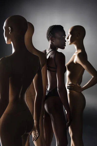 Joven Afroamericano Modelo Bodysuit Pie Entre Maniquíes Negro — Foto de stock gratis