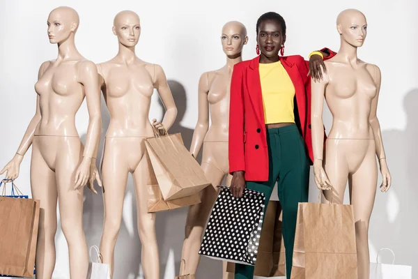 时尚的非洲裔美国女孩微笑着在相机 而站在模特之间的购物袋 — 图库照片