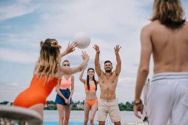Genç erkek ve kadınlar voleybol birlikte sahilde oynarken
