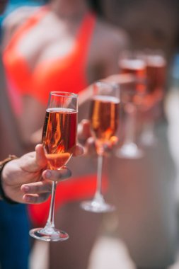 Gençler bardak şarap güneşli gün, seçici odak tutarak kısmi görmek