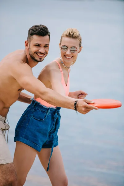 Gelukkige Jonge Paar Spelen Met Frisbee Strand — Gratis stockfoto