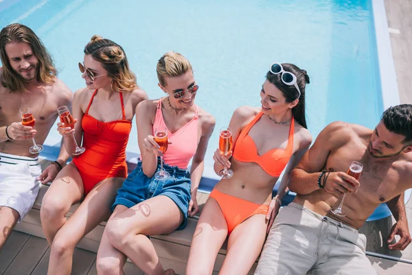 Vista Ángulo Alto Jóvenes Amigos Sonrientes Bebiendo Champán Descansando Piscina —  Fotos de Stock