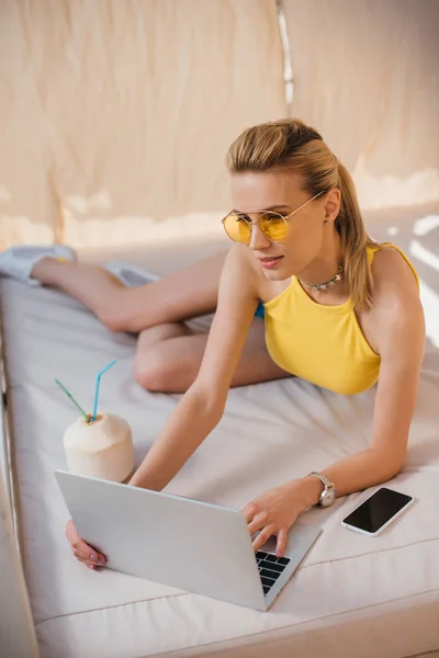 Menina Bonita Óculos Sol Usando Laptop Enquanto Descansa Bungalow — Fotografia de Stock