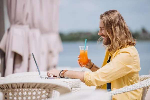 Side View Smiling Young Man Holding Cocktail Using Laptop Beach — Stock Photo, Image