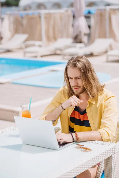 Schöner Junger Mann Trinkt Cocktail Während Pool Sitzt — kostenloses Stockfoto