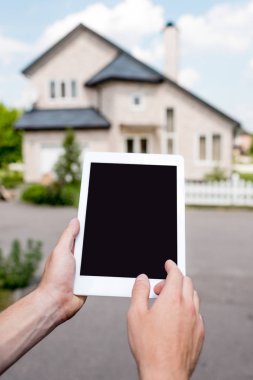 Dijital tablet ile boş perde yazlık önünde tutan adamın kısmi görünümü 
